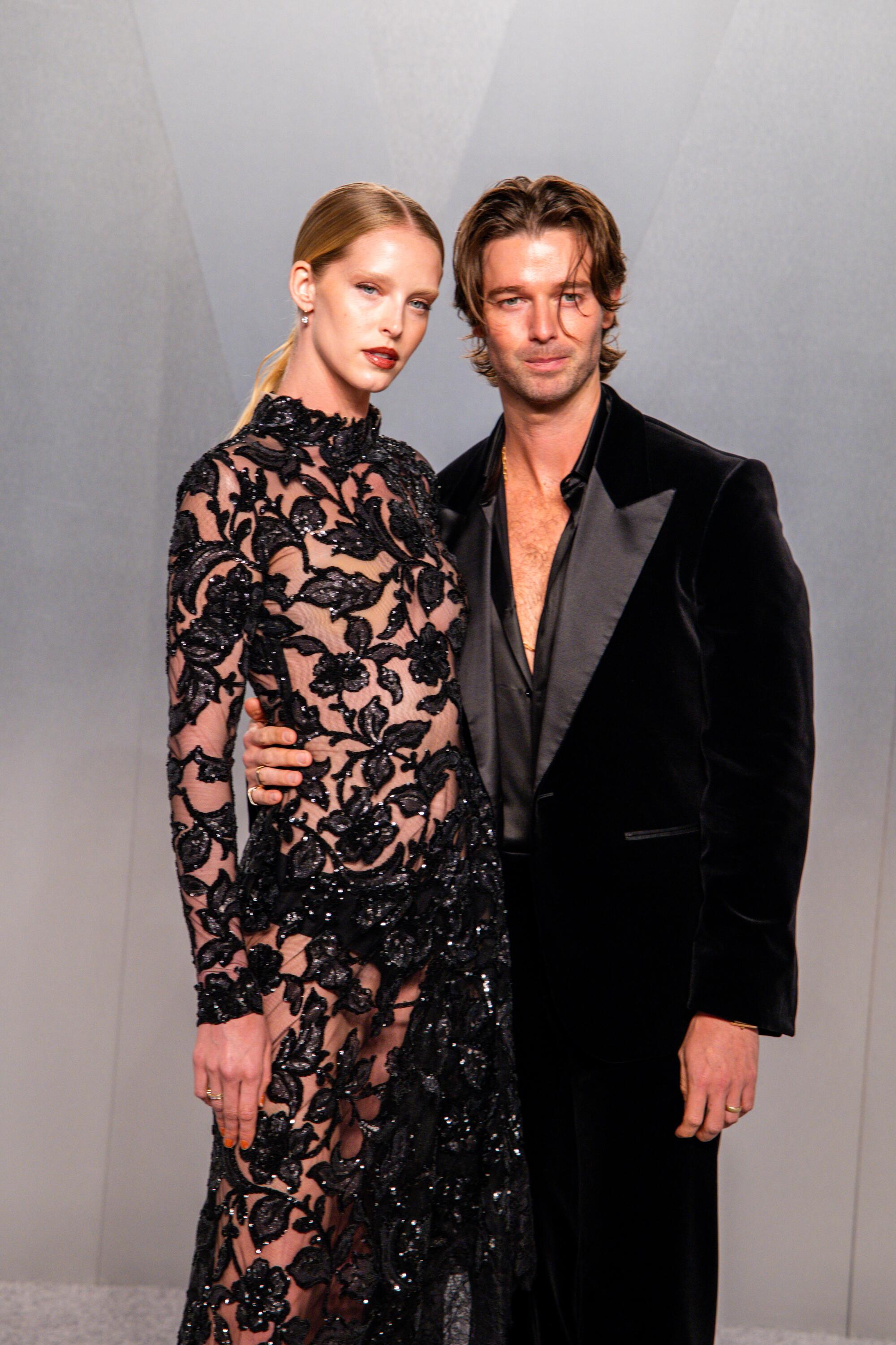 Abby Champion and Patrick Schwarzenegger pose on the red carpet. 