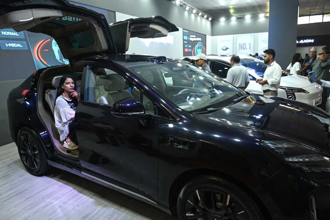 In this photograph taken on September 1, 2024, visitors look at electric vehicles in Kathmandu, Nepal.