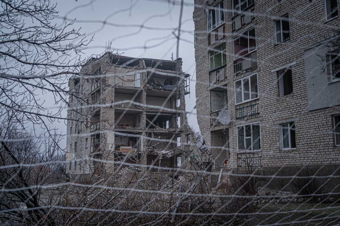 Nets along the city streets in Izium, Ukraine in front of a building that's been destroyed by a Russian attack.
