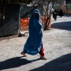 A woman in Herat, wearing a burqa, This photograph taken on January 8, 2026 shows an Afghan burqa-clad woman walking with her child at the Medecins Sans Frontieres (MSF) centre inside a hospital in Herat. In the country of more than 40 million people, there are relatively few medical centres that can help treat malnutrition. Some families travel hundreds of kilometres (miles) to reach Herat hospital as they lack healthcare facilities in their home provinces.