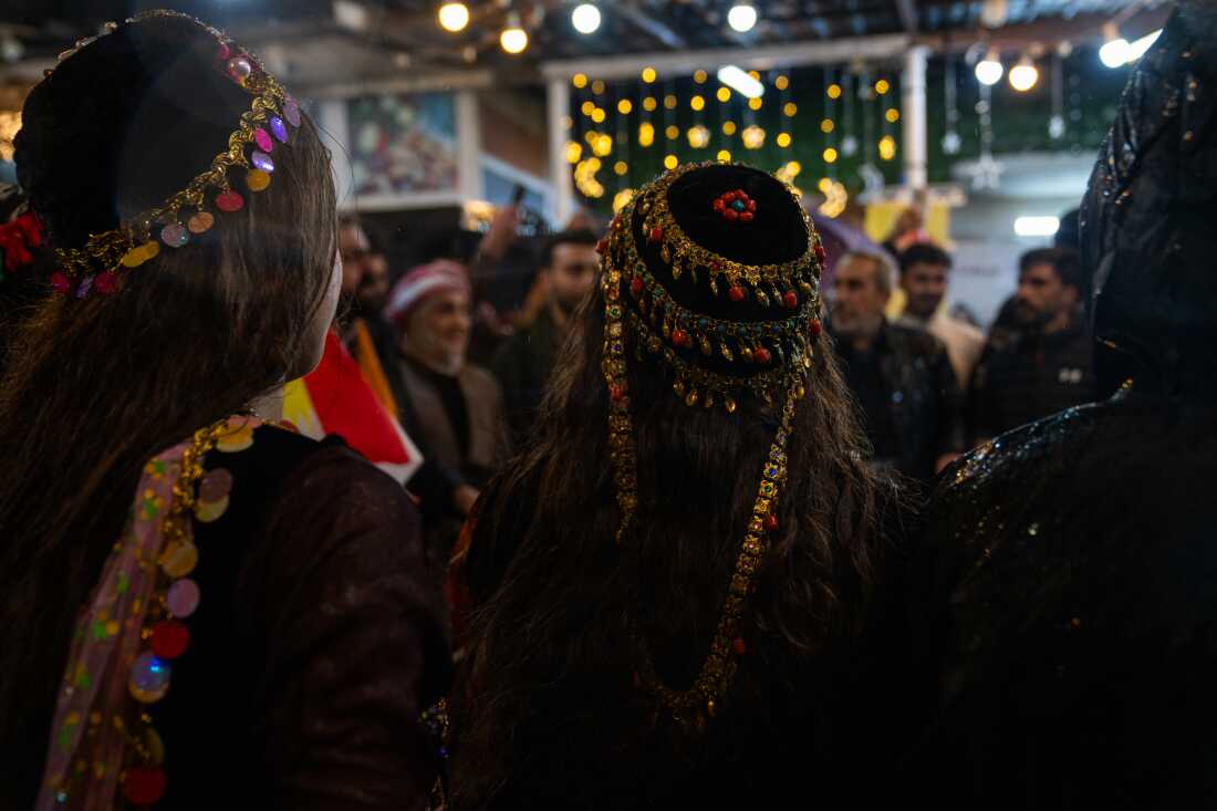 Women wear gold Kurdish headdresses on Friday while gathering in the city's plaza.