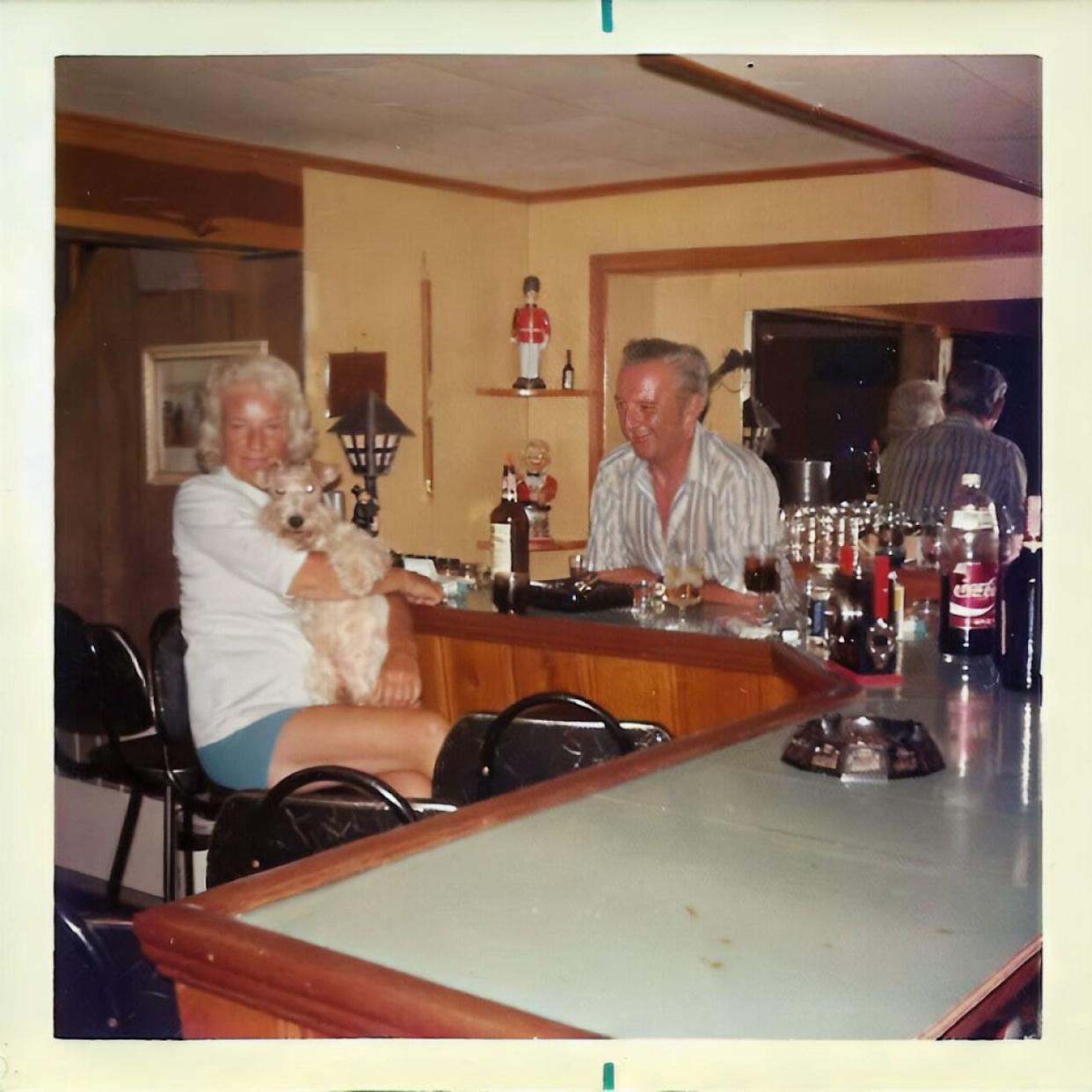 An older couple sitting around in their basement bar -