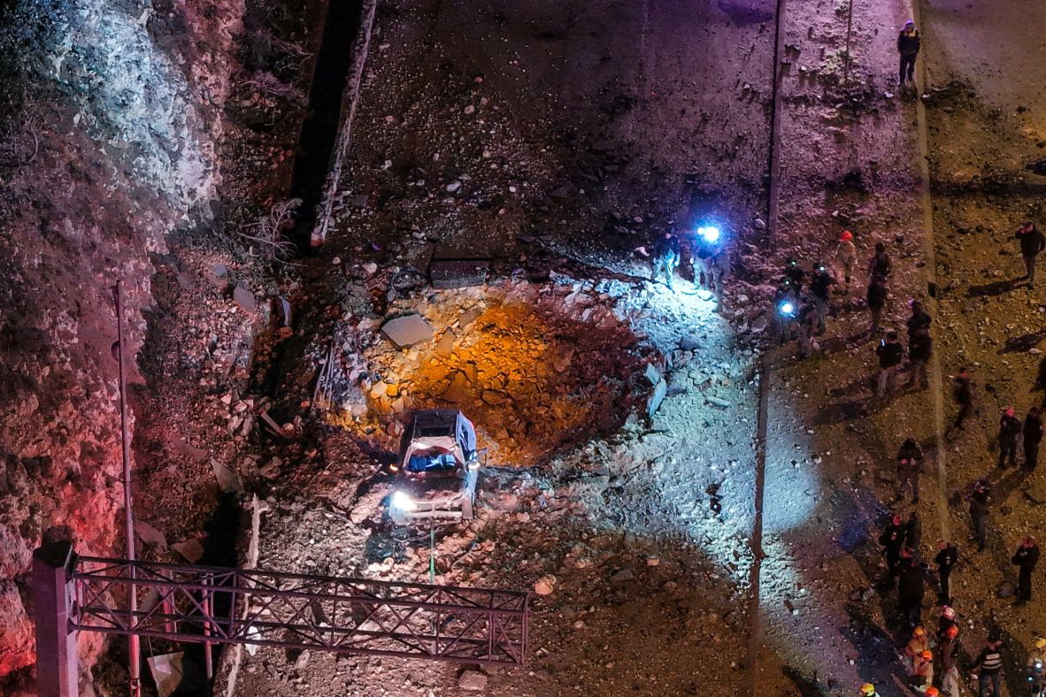 Israeli emergency responders work at the scene of a missile strike on a road in Jerusalem on March 1.