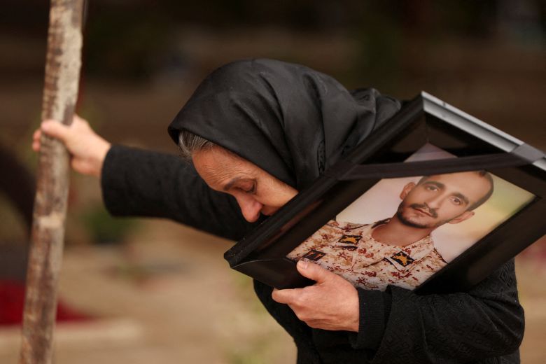 Marzia Rezaei reacts while standing near the grave of her son, Erfan, who was killed in strikes amid the US-Israeli conflict with Iran, at Behesht-e Zahra cemetery, in Tehran, on March 16.