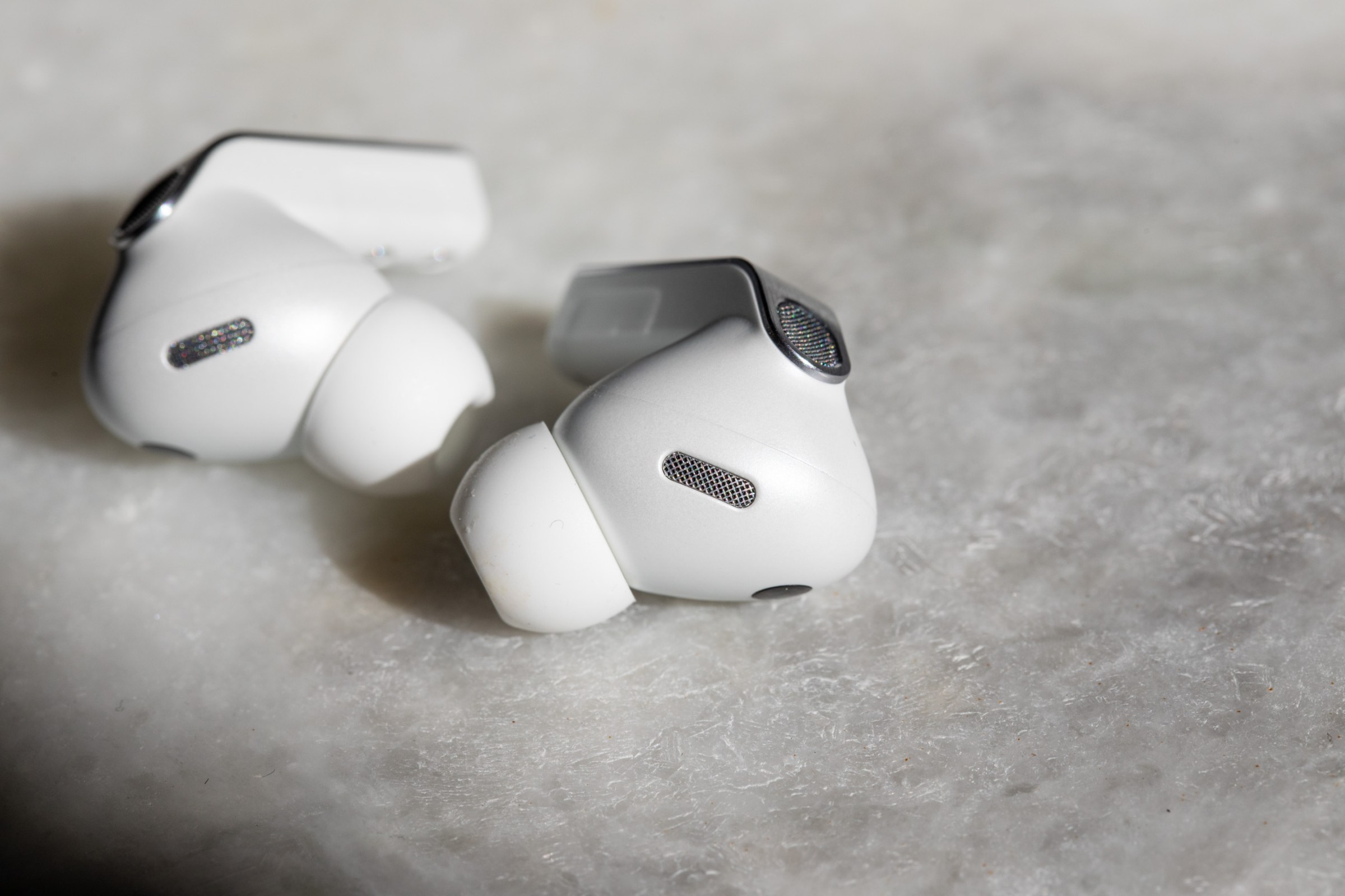 The Samsung Galaxy Buds 4 Pro earbuds on a white marble table.