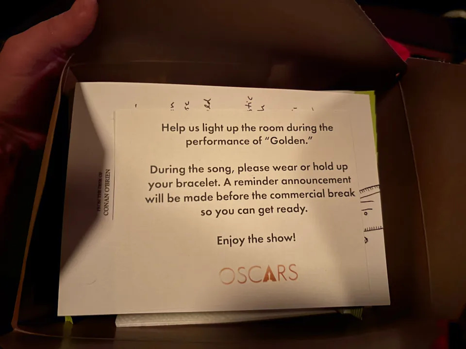 Card inside a box with printed instructions asking Oscars audience members to light up bracelets during the performance of Golden.
