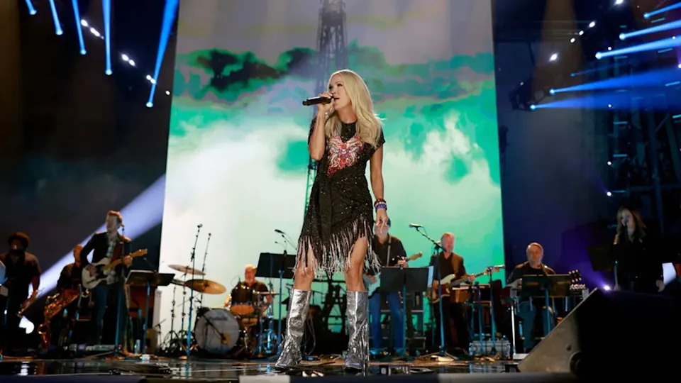 American Idol judge Carrie Underwood rocks silver boots and black dress at Toby Keith tribute.