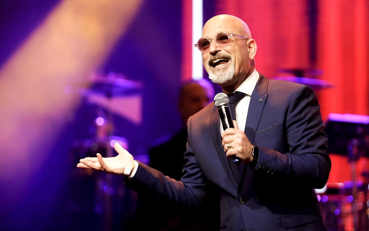 Howie Mandel on stage with a microphone