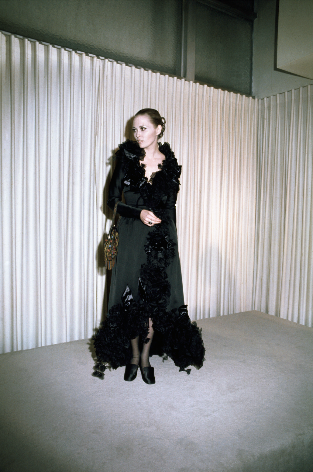 a person wearing a dramatic black dress with floral embellishments