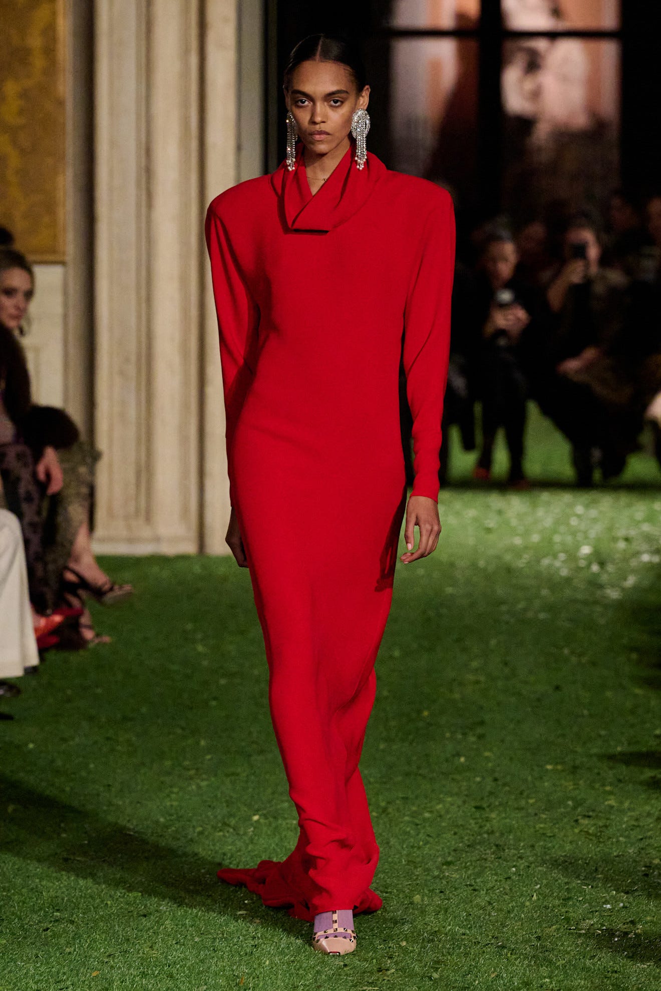 fashion model showcasing a red dress on a runway