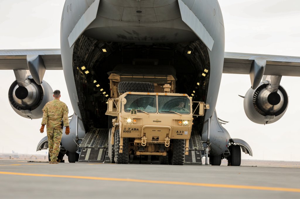 U.S. Army Soldiers from the 1st Battalion, 7th Air Defense Artillery Regiment, 108th Air Defense Artillery Brigade, load equipment and trucks onto a C-17 Globemaster III with U.S. Air Force Airmen assigned to the 21st Expeditionary Airlift Squadron at an undisclosed location in the CENTCOM Area of Operations, Dec. 31, 2023. U.S. Army air defense artillery batteries are highly mobile, capable of deploying swiftly across the globe to support and defend U.S. troops and partners. (U.S. Army photo by Sgt. Christopher Neu)