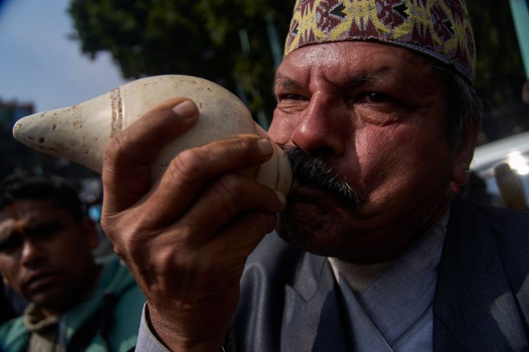 A supporter blows a conch shell as people gather to welcome Nepal's former King Gyanendra Shah upon his arrival at Tribhuvan International Airport in Kathmandu, Nepal, Friday, Feb. 13, 2026. (AP Photo/Niranjan Shrestha)