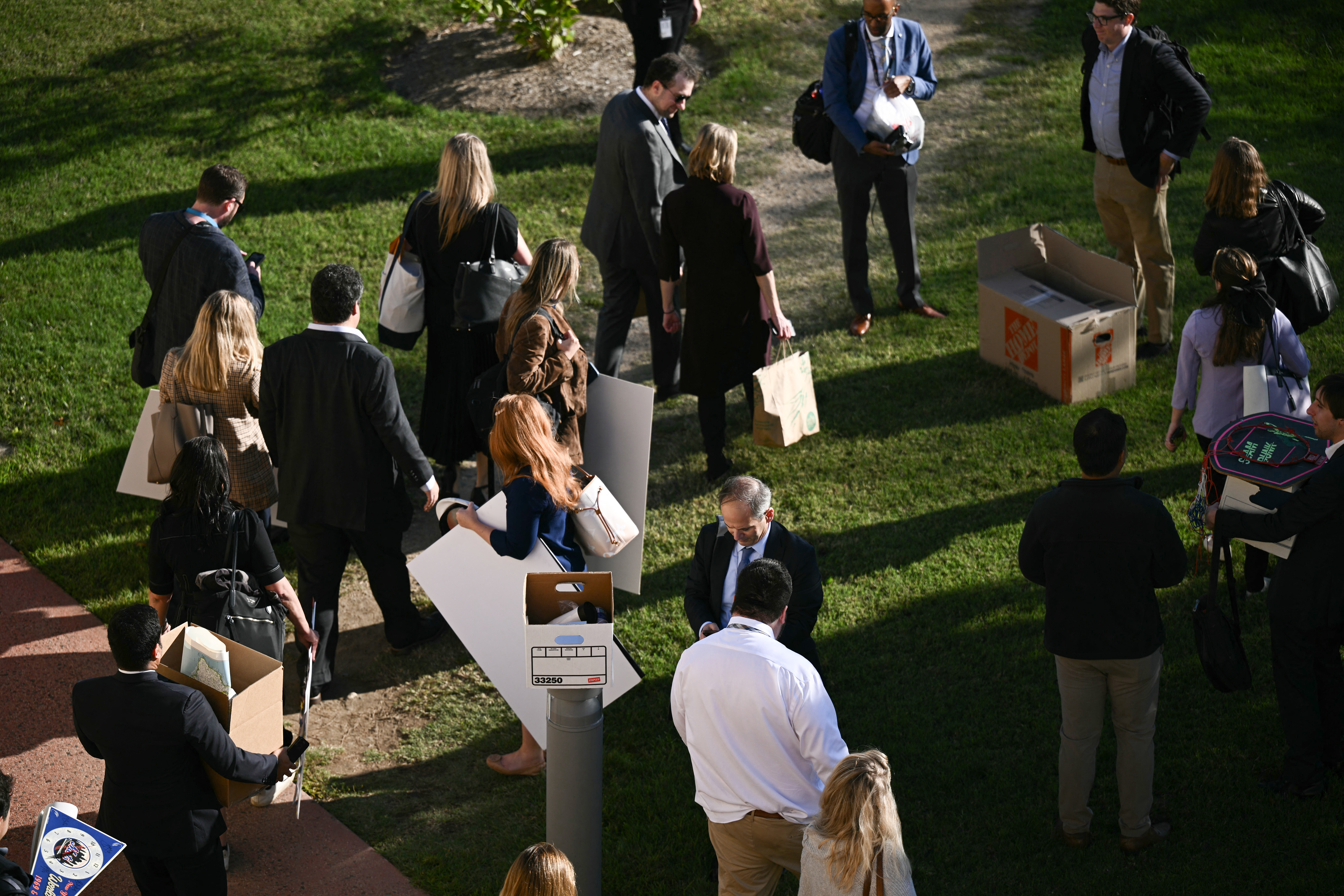 Reporters carry their belongings from the Pentagon in Washington, DC, on October 15, 2025 after US and international news outlets including The New York Times, AP, AFP and Fox News declined to sign new restrictive Pentagon media rules, and were stripped of their press access credentials. The new rules come after the Defense Department restricted media access inside the Pentagon, forced some outlets to vacate offices in the building and drastically reduced the number of briefings for journalists. (Photo by Brendan SMIALOWSKI / AFP) (Photo by BRENDAN SMIALOWSKI/AFP via Getty Images)