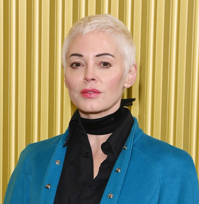 Woman with short blonde hair wearing a black shirt and blue jacket, related to Kaley Cuoco calls out former co-star news. Woman with short blonde hair wearing a black shirt and blue jacket, related to Kaley Cuoco calls out former co-star news.