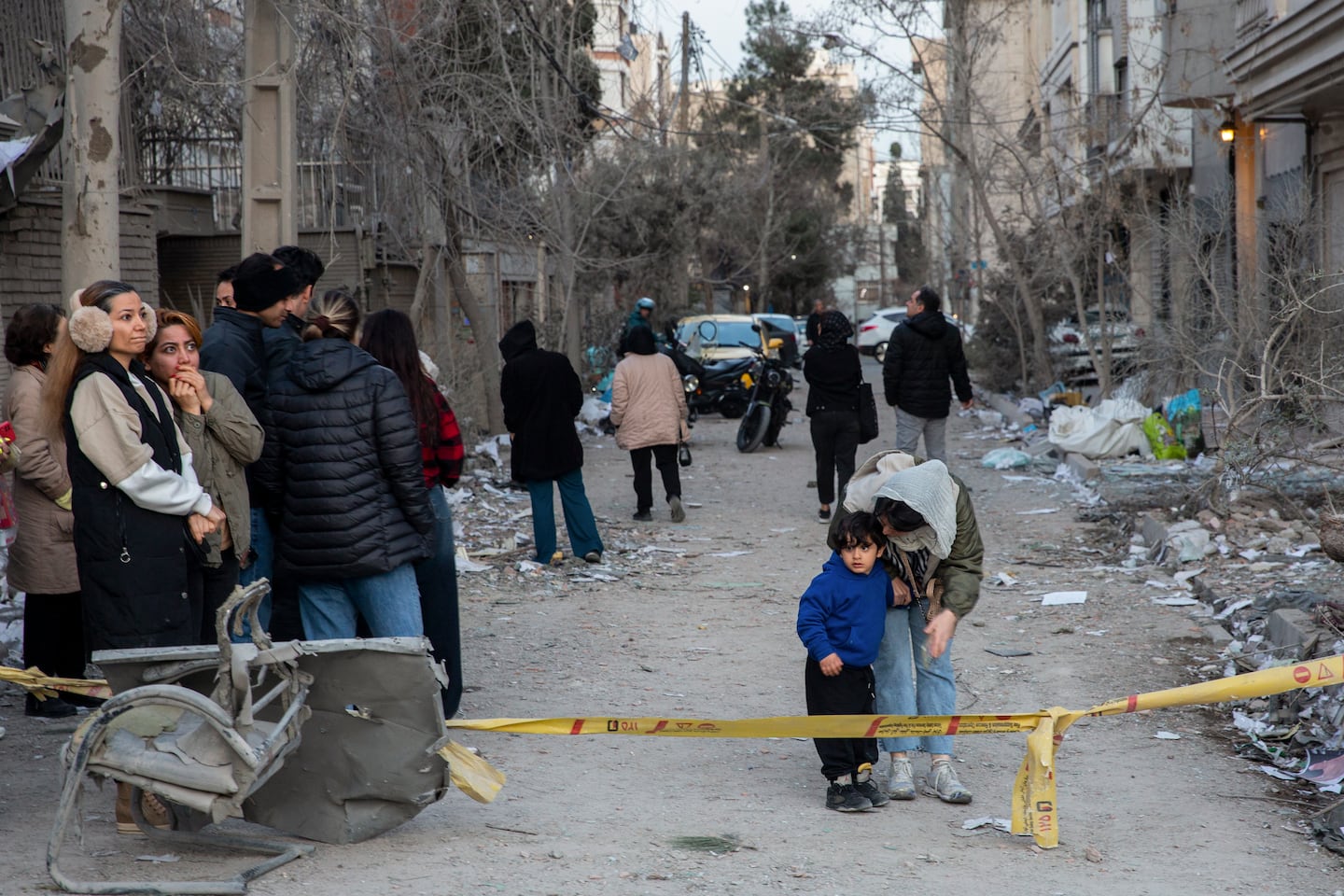 People stand near a tape line after a police station was struck by airstrikes in Tehran, Iran, March 2, 2026. 
