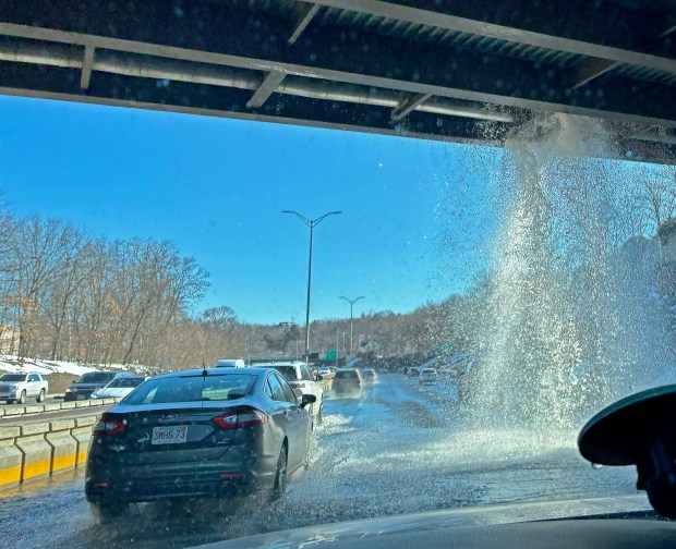 A broken water main dumps water on the Southeast Expressway in Milton. (Staff photo by Stuart Cahill)