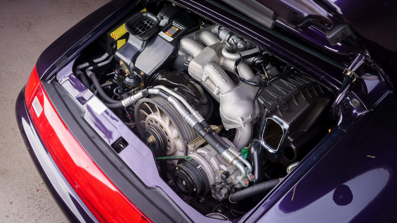 The open engine bay of a purple 1997 air-cooled 993-generation Porsche 911 Carrera