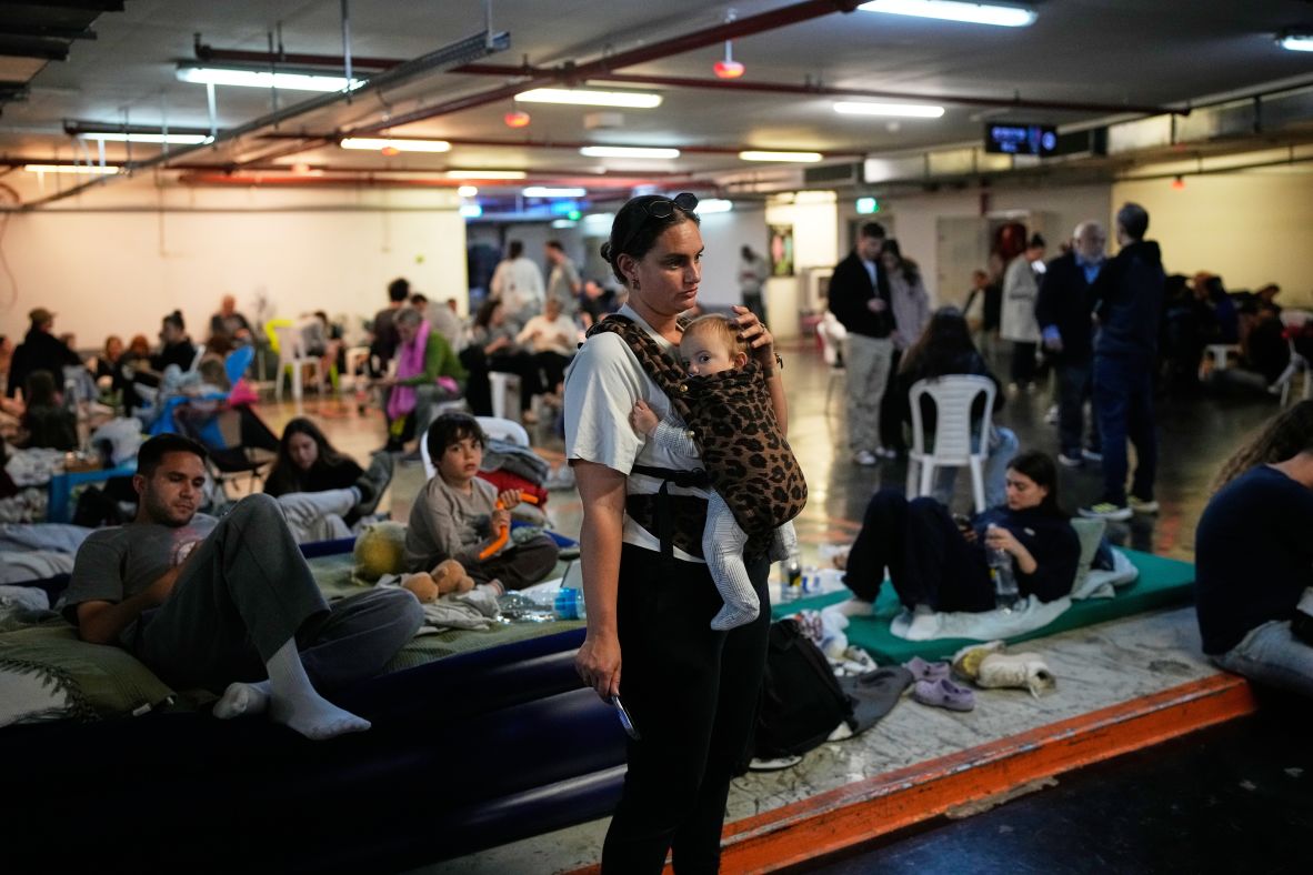 Leah Guttmann holds her son, Teddy, while taking shelter in an underground parking garage as air-raid sirens warn of incoming missiles in Tel Aviv, Israel.