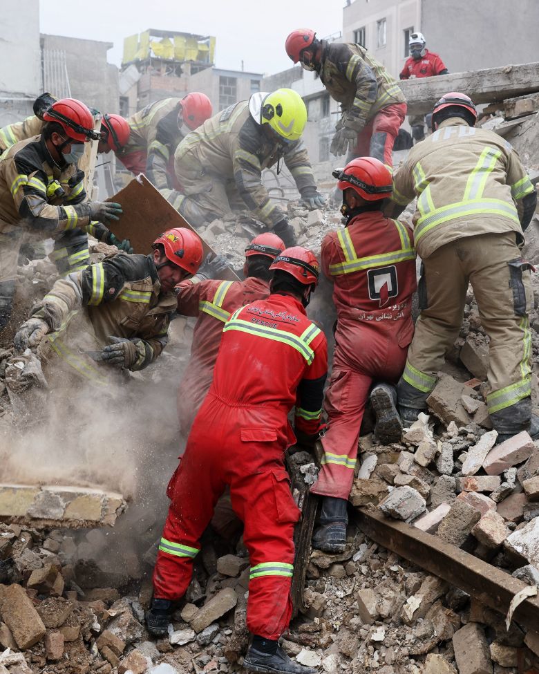 Rescue workers search for survivors in the rubble, after a strike in southern Tehran, Iran, on March 13.