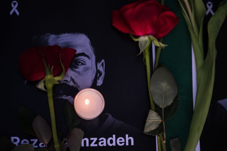 Roses and a candle rest on a photo said to be of an Iranian protester, during a community gathering in Los Angeles' Encino neighborhood.