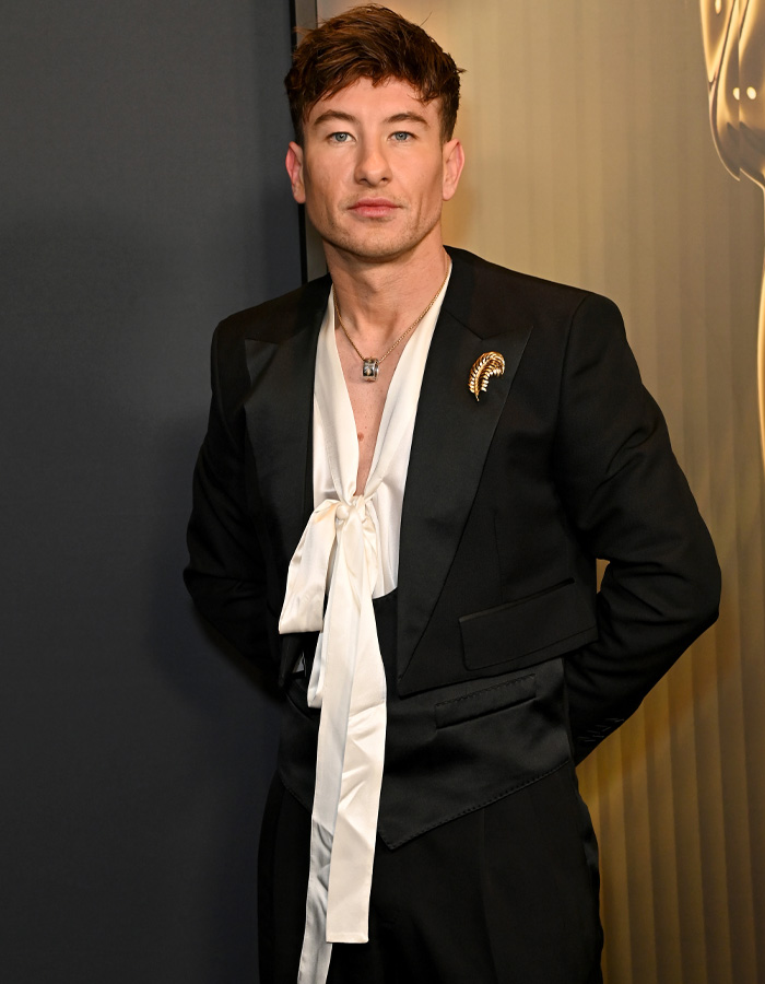 Barry Keoghan in a black suit with a white satin tie detail, posing at an event amid acting career reconsideration and fan backlash.