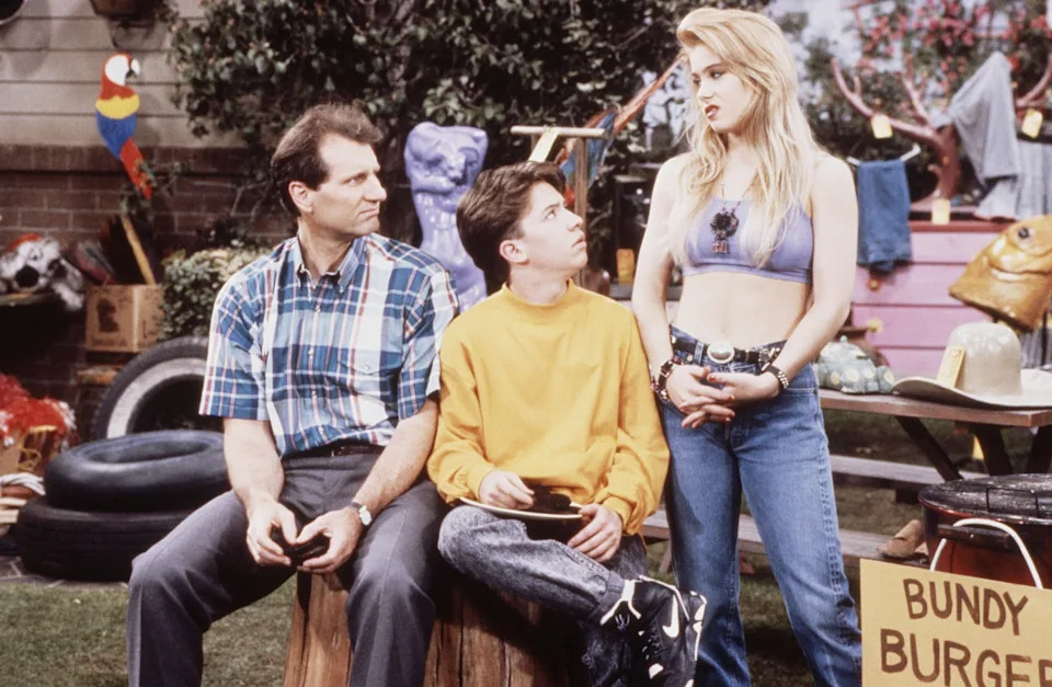 Al and Bud Bundy look quizzically at Kelly in their crowded backyard.