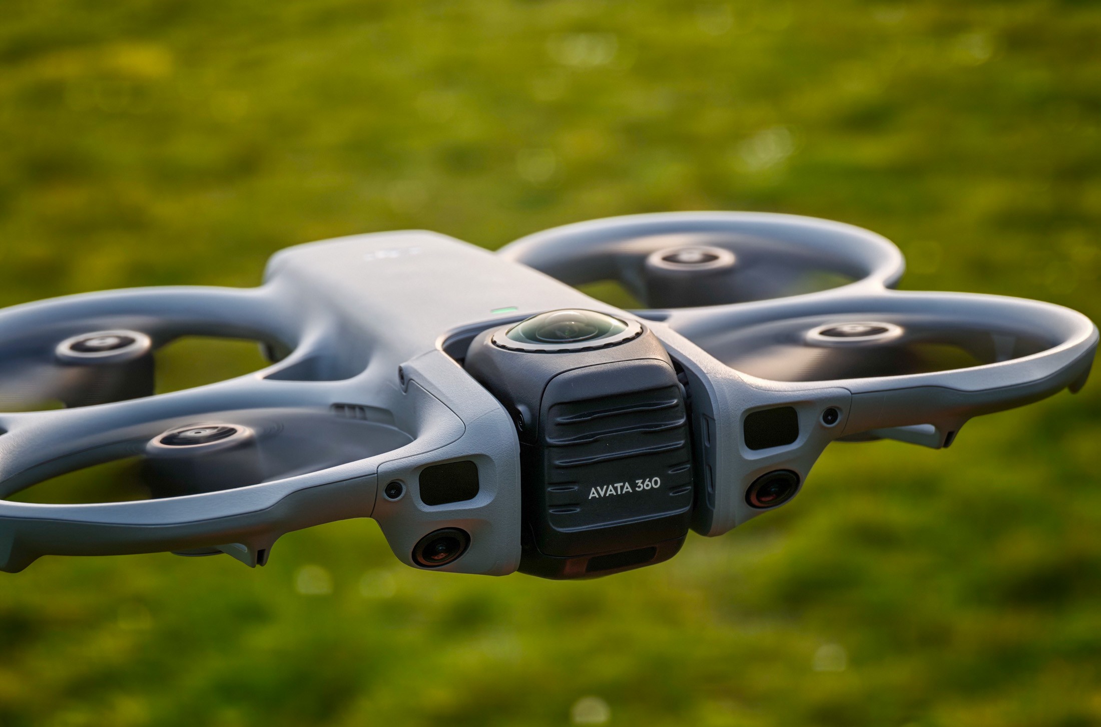 Photo of the DJI Avata 360 hovering above grass
