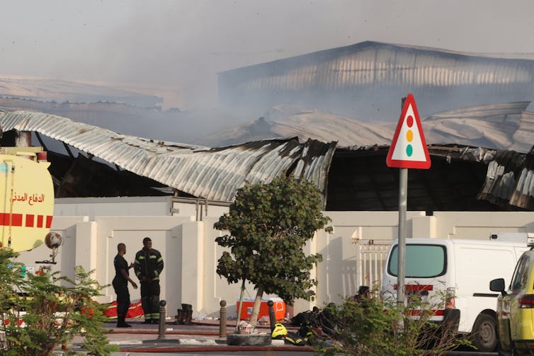 Smoke rises from a damaged warehouse.