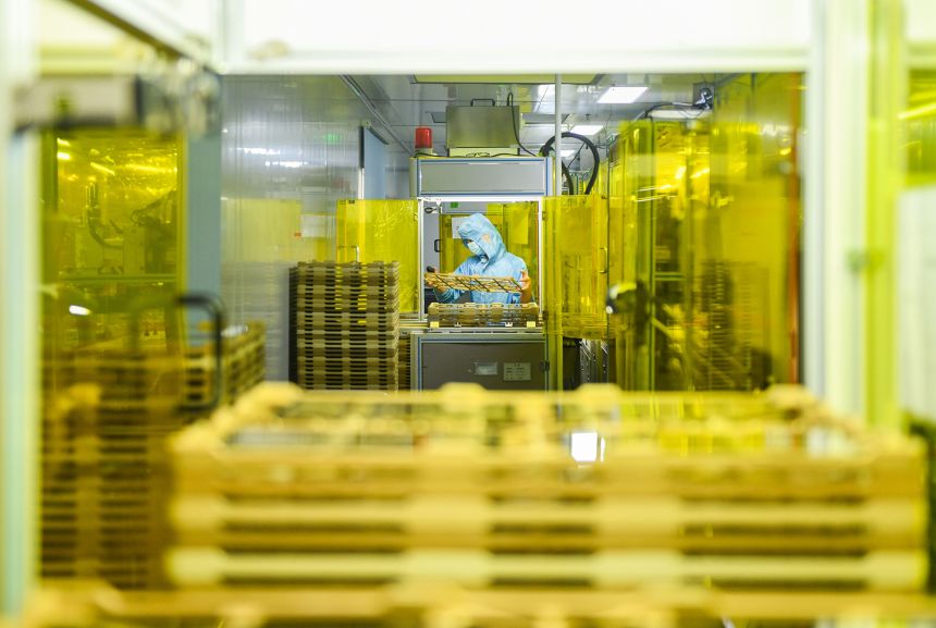 A worker operates on the production line of touchscreen glass cover at Hunan Wobo Technology Co., Ltd. on June 12, 2025 in Yongzhou, Hunan province.