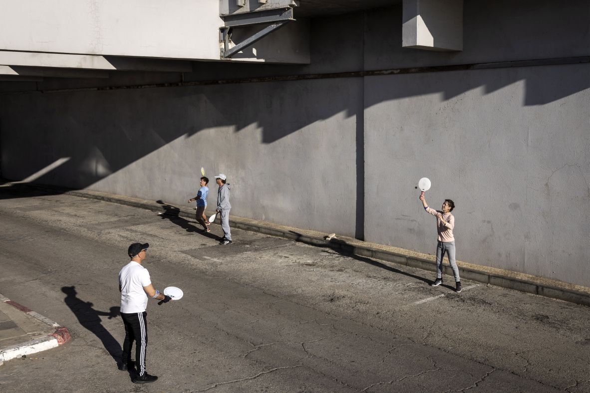 People play racketball outside an underground parking garage used as a shelter in Tel Aviv, Israel.