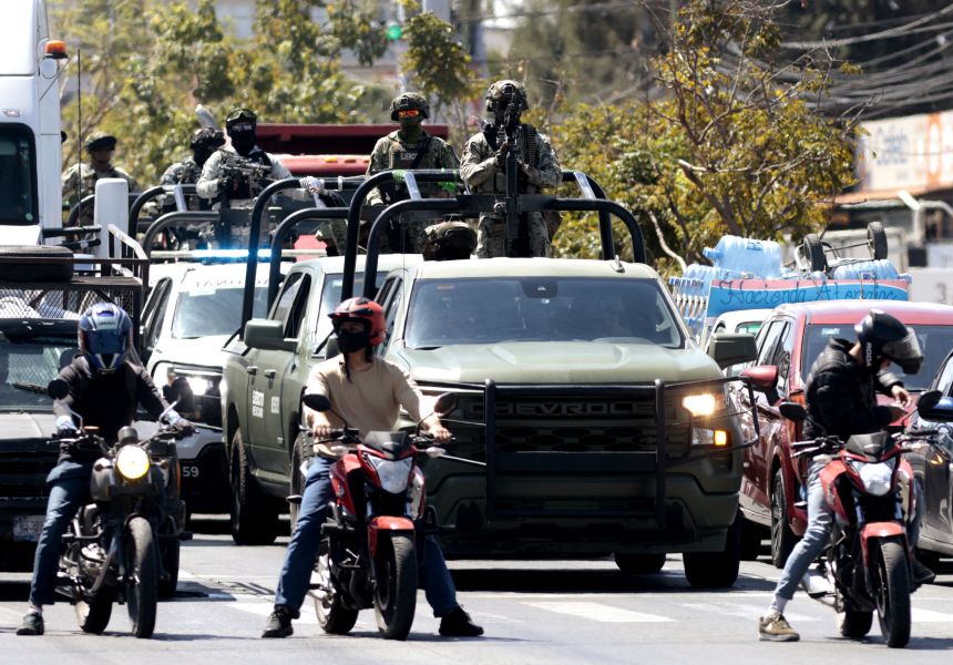 Mexican soldiers patrol the area as the hearse of drug trafficker Nemesio 