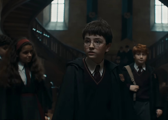 Young wizard character in Hogwarts robes in a dimly lit hall amid fans reacting to Harry Potter series race change news.
