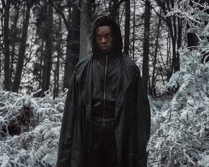 Actor in dark cloak standing in snowy forest, related to HBO Harry Potter series trailer character race change controversy.