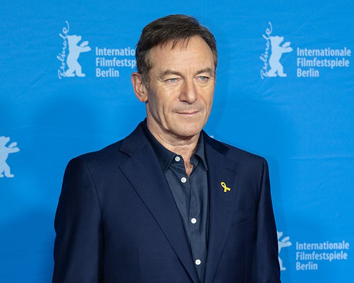 Man in dark blue suit standing in front of Berlinale backdrop at International Film Festival Berlin event about HBO's Harry Potter series.