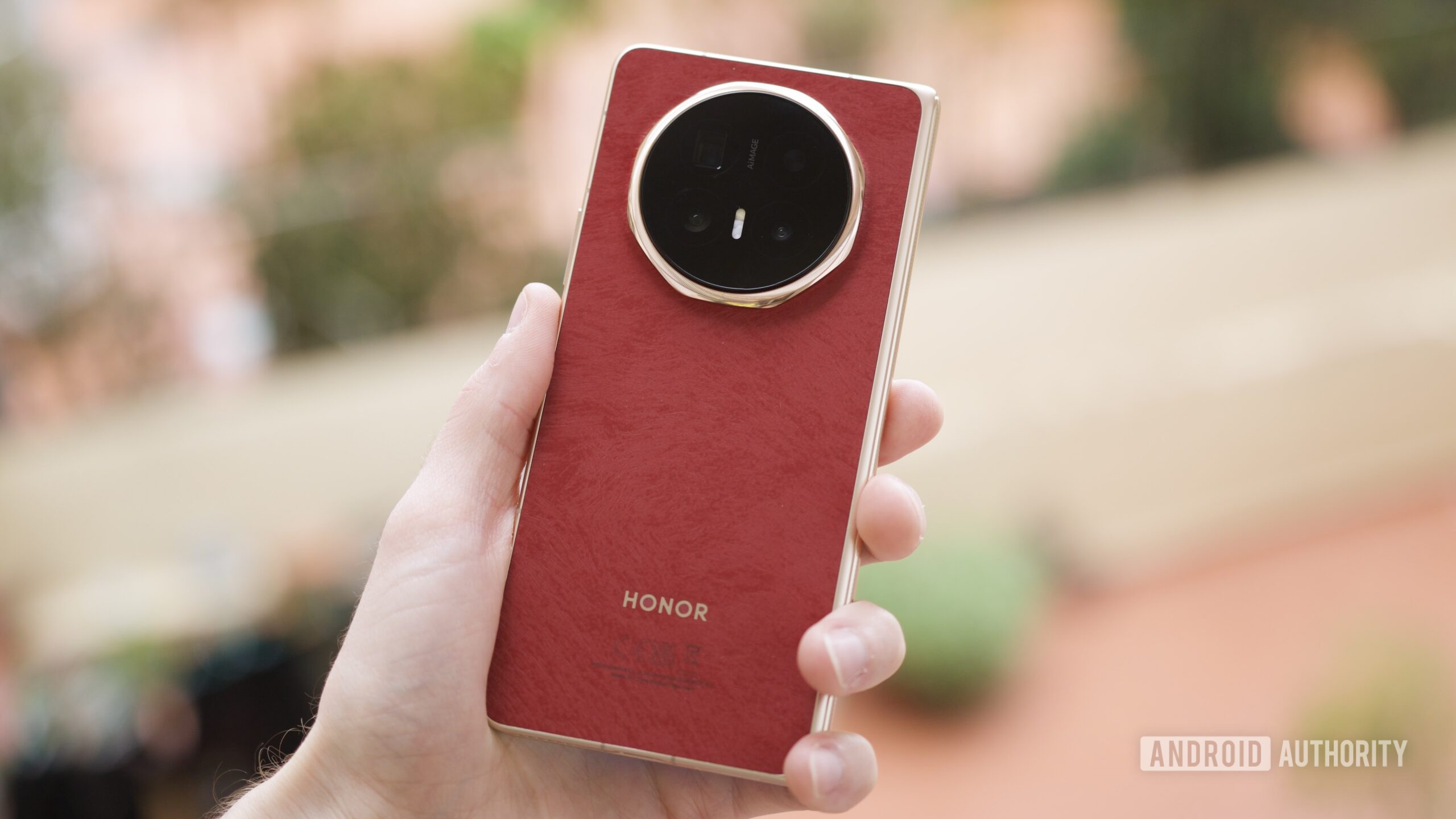 Someone holding the red HONOR Magic V6.