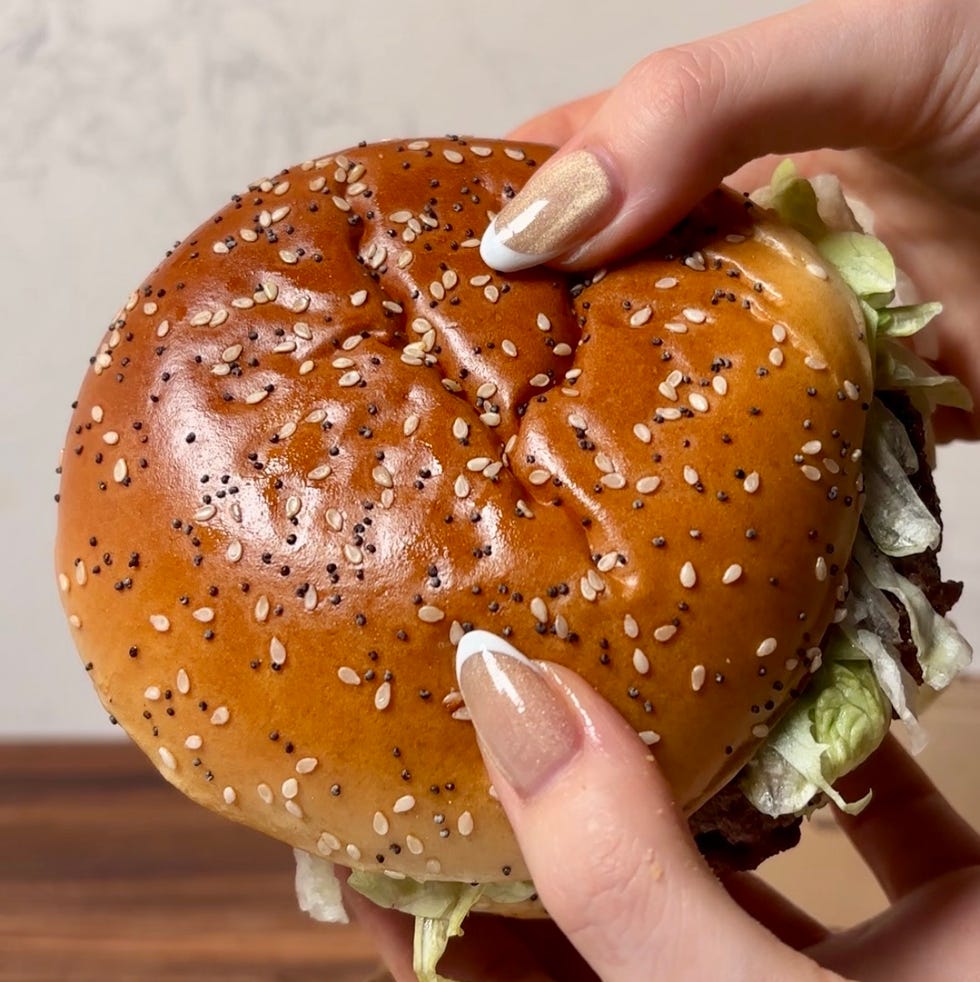 hand holding a sesame seed bun burger