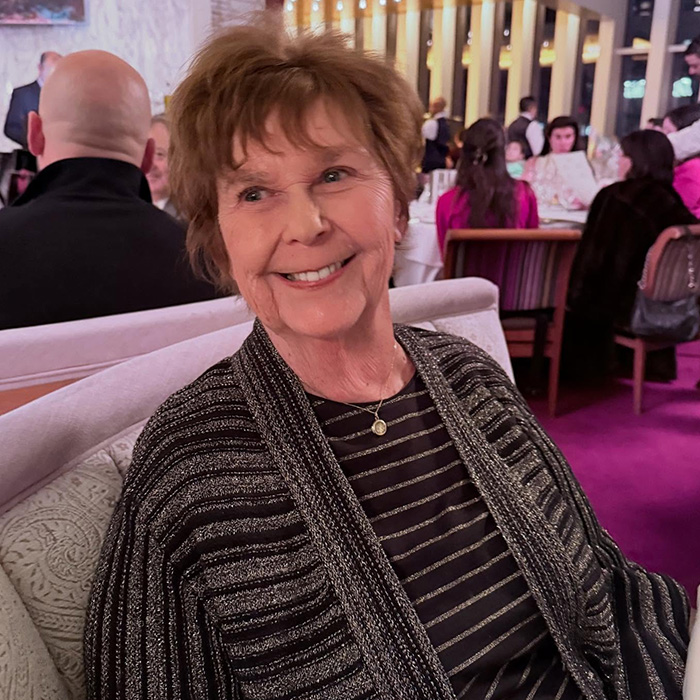 Older woman smiling in a crowded restaurant setting, highlighting behind-the-scenes toxic drama amid Today Show return.
