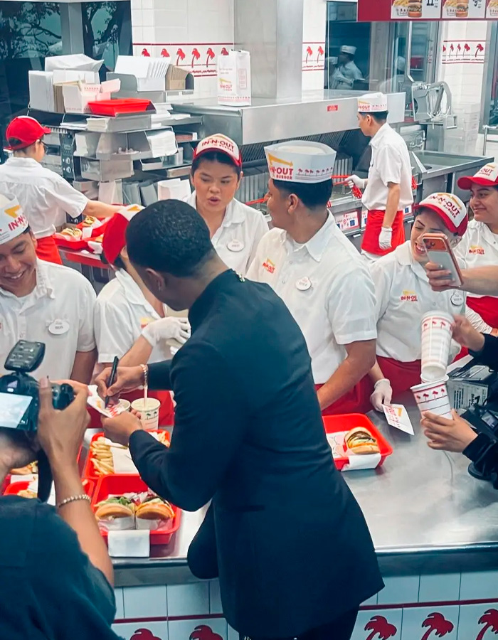Michael B. Jordan signing autographs and interacting with employees at an In-N-Out restaurant after the Oscars event.