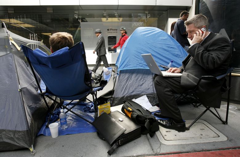 Dale Larson talks on his cellular telephone while waiting in line before the initial sale of the Apple iPhone in San Francisco, California June 29, 2007.