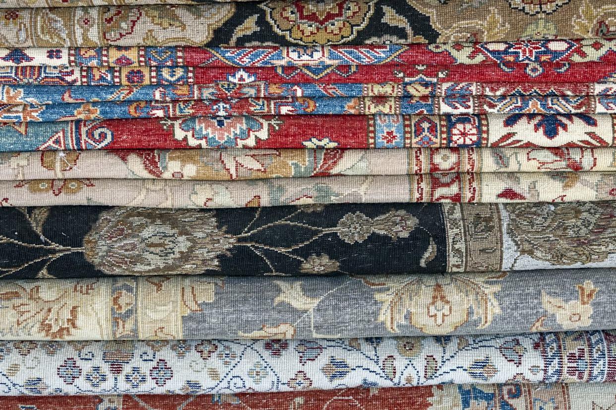 stack of folded turkish rugs in a shop near kuşadası, turkey