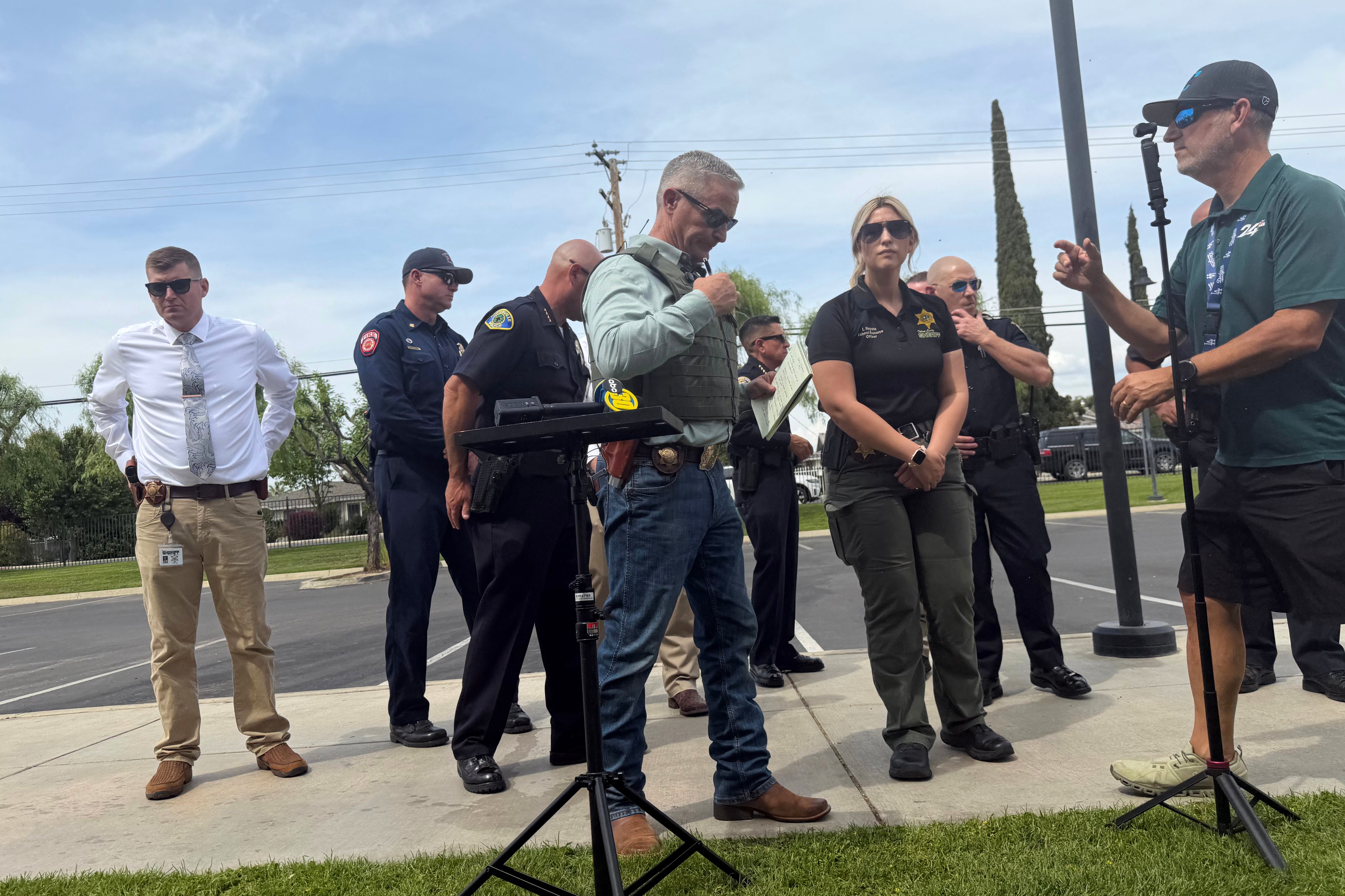 Tulare County Sheriff Mike Boudreaux, center, attends a news conference after a sheriff's deputy was shot and killed Thursday