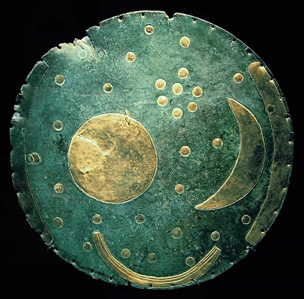 Moon and star celestial symbols on metallic artifact, possibly ancient or artistic representation of.