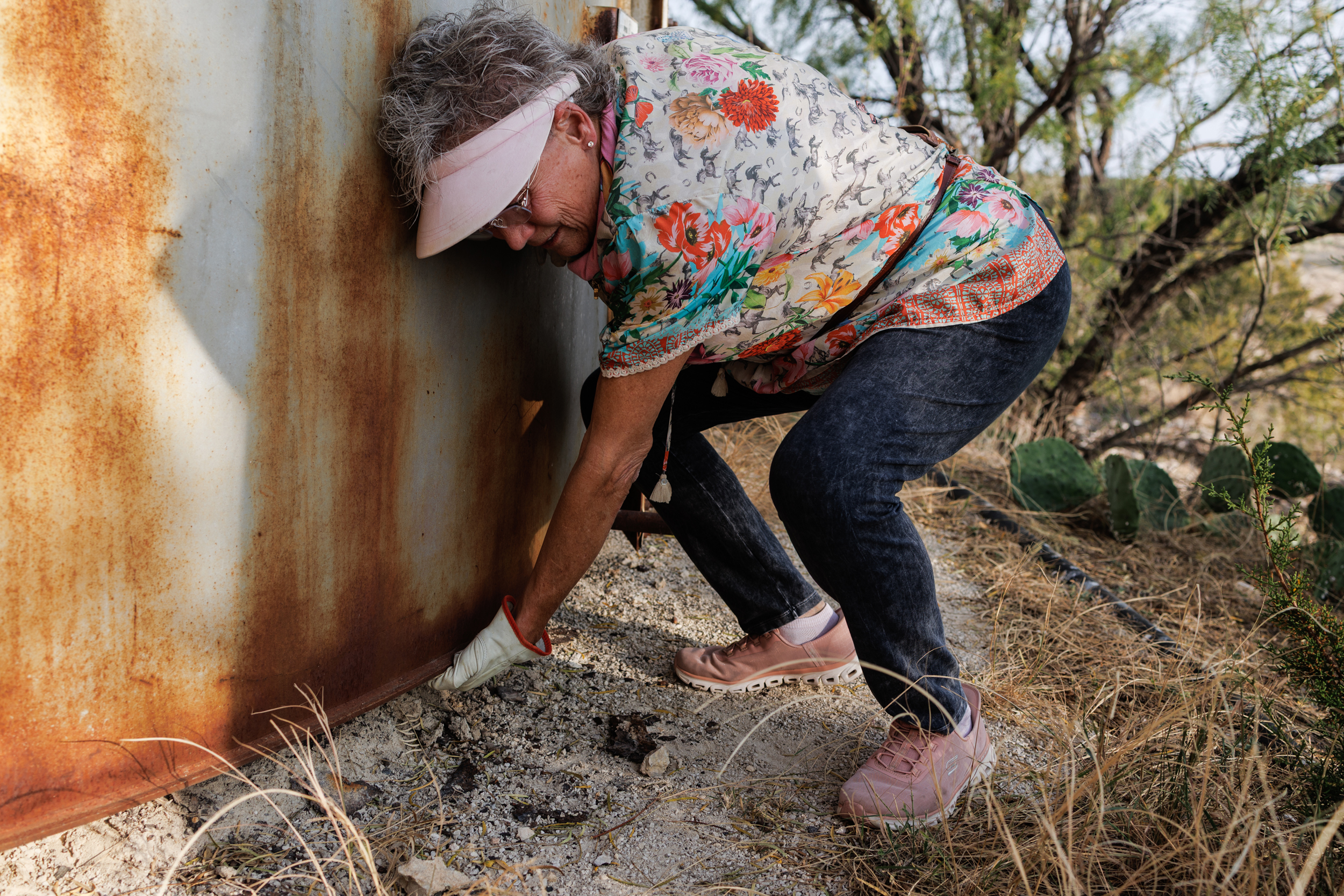 Jackie Chesnutt feels underneath a tank that is rusted out on its base. It’s part of a tank battery operated by CORE Petro Chesnutt’s property near Knickerbocker, Texas.